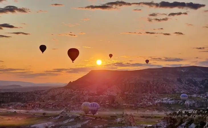 Kapadokya’da gün doğumunda vadiler üzerinde yükselen sıcak hava balonları